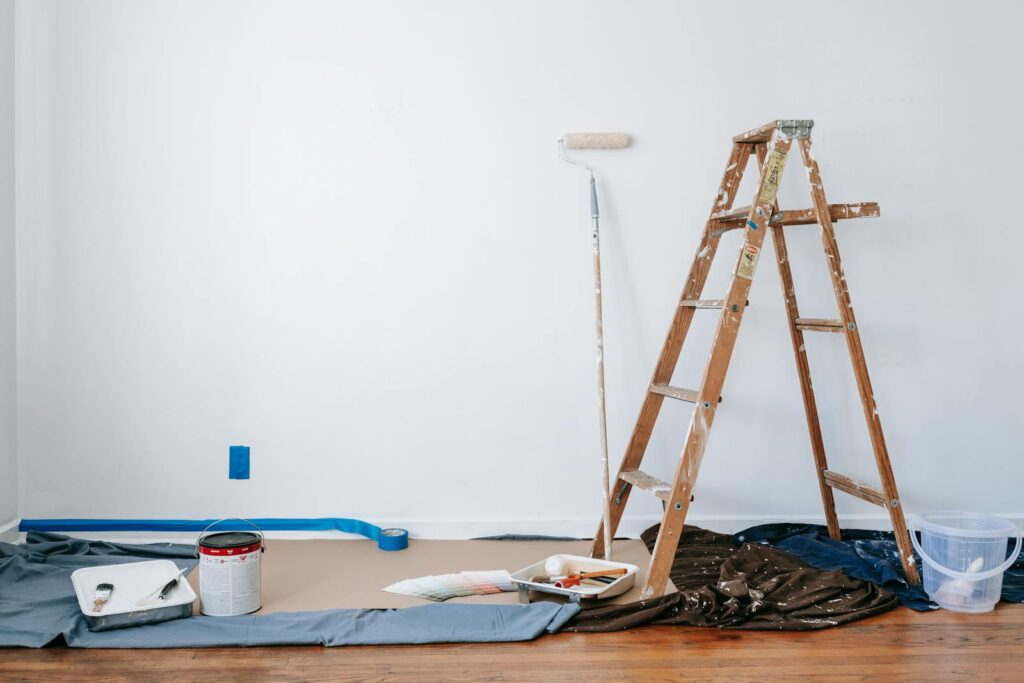 A room prepared for renovation with a ladder, paint supplies, and drop cloth for Senior-Friendly Home Modifications: Essential Upgrades for Safety & Comfort