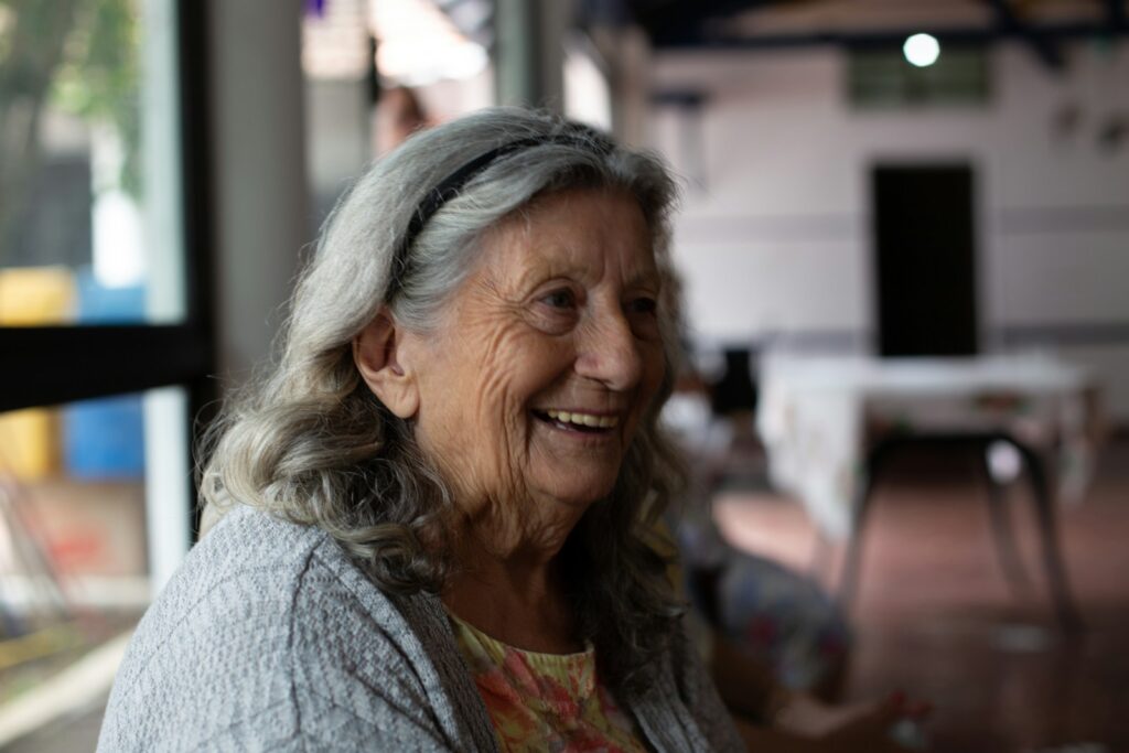 smiling woman in gray cardigan for Make Home From Us